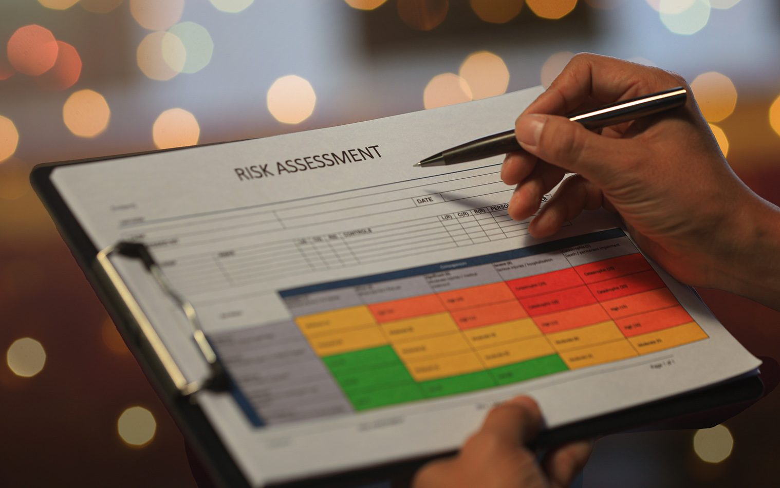 Manager reviewing a risk assessment report on a clipboard with matrix chart.