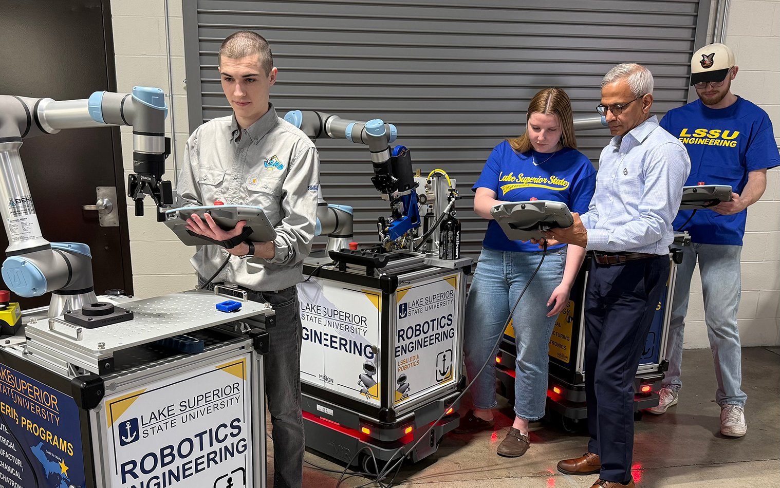 Jim Devaprasad helps students in his LSSU Cobot lab class.