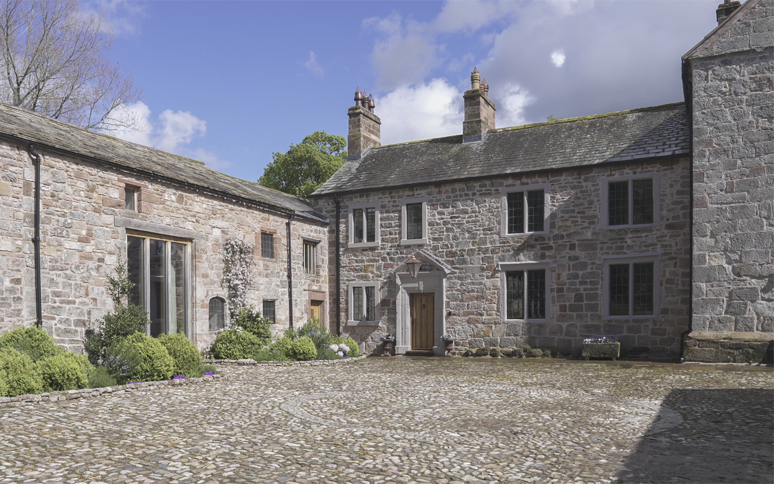 14th-century stone farm buildings in northern England with a cobblestone courtyard