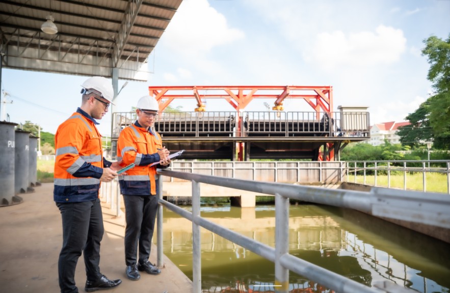Two workers with clipboards at a water plant